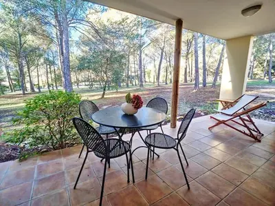 a table with chairs and a vase on it on a patio at Escale détente - Résidence 4* au sein d'un Golf in Saumane-de-Vaucluse