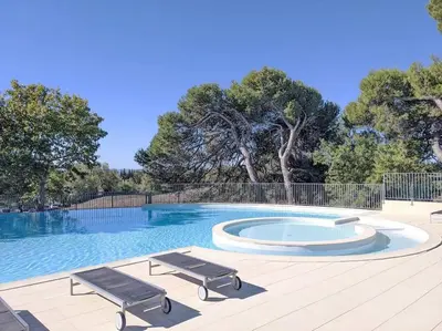 a swimming pool with two chairs and a bench at Escale détente - Résidence 4* au sein d'un Golf in Saumane-de-Vaucluse