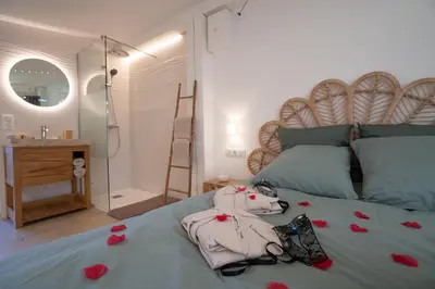 a bedroom with a bed with red roses on it at Lovina chambre de charme avec jacuzzi in Velaux