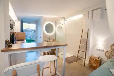 a kitchen and living room with a table and chairs at Lovina chambre de charme avec jacuzzi in Velaux