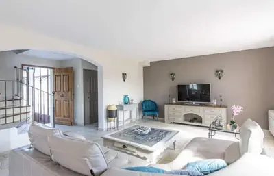 a living room with white furniture and a flat screen tv at La marinette in Fontaine-de-Vaucluse