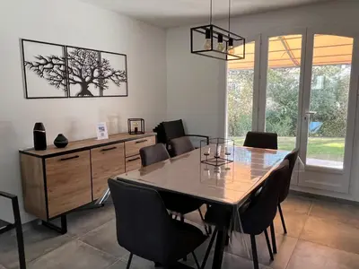 a dining room with a table and some chairs at Golf de Pont Royal Villa des Alpilles climatisée 3 chambres Piscine chauffée Parking et Garage in Mallemort