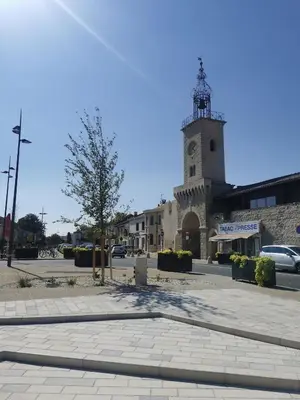 a building with a clock tower on a street at Studio en pleine campagne in Le Thor