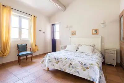 a bedroom with a bed and a chair at Mas de Lure in Salon-de-Provence
