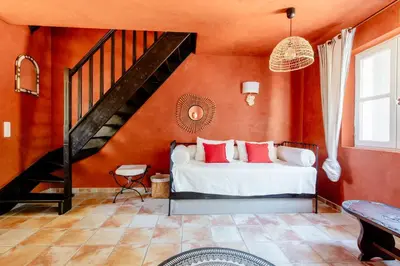 a bedroom with orange walls and a bed with red pillows at Mas de Lure in Salon-de-Provence