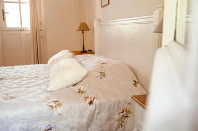 a bedroom with a white bed with flowers on it at Mas de Lure in Salon-de-Provence