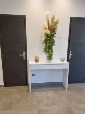 a white table with a vase of flowers on it at Villa contemporaine in Pernes-les-Fontaines