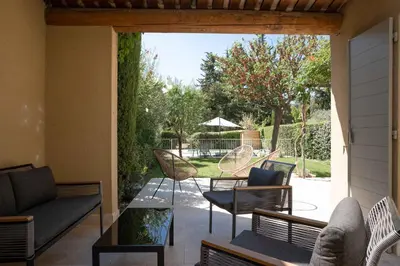 a patio with chairs and a couch and a table at Maison Cocoon Lourmarin 6 personnes in Lourmarin