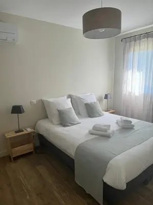 a white bedroom with a large bed with white pillows at Maison Cocoon Lourmarin 6 personnes in Lourmarin