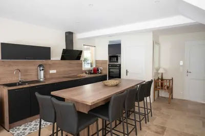 a kitchen with a wooden table and chairs at Maison Cocoon Lourmarin 6 personnes in Lourmarin