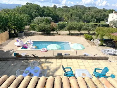 an outdoor swimming pool with chairs and umbrellas at Maison avec piscine - Luberon in Saint-Saturnin-les-Apt