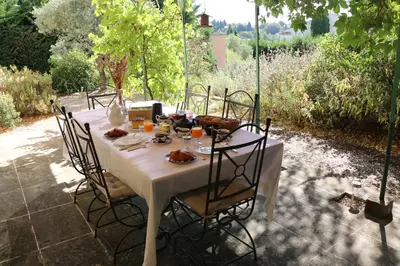 a white table with chairs and food on it at Les Chambres de Fanny in Cabrières-dʼAigues