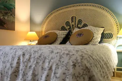 a bed with a white bedspread and pillows on it at Les Chambres de Fanny in Cabrières-dʼAigues