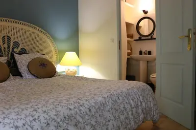 a bedroom with a bed and a lamp and a sink at Les Chambres de Fanny in Cabrières-dʼAigues