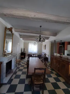 a living room with a table and a fireplace at Maison Rosiris in Pernes-les-Fontaines