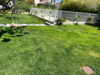 a yard with green grass and a fence at Villa climatisé avec piscine et jacuzzi in Carpentras