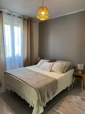 a bedroom with a large bed with a large window at Villa climatisé avec piscine et jacuzzi in Carpentras