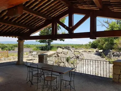 a patio with a table and chairs and a fence at Maison de caractère dans Luberon avec piscine in Saignon