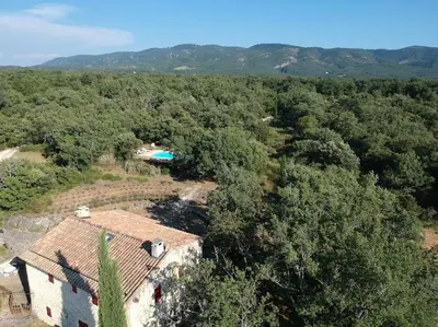 an aerial view of a house in the middle of a forest at Maison de caractère dans Luberon avec piscine in Saignon