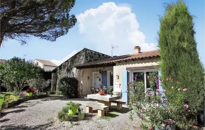 a stone house with a bench in the yard at Lovely Home In Cheval-Blanc in Cheval-Blanc