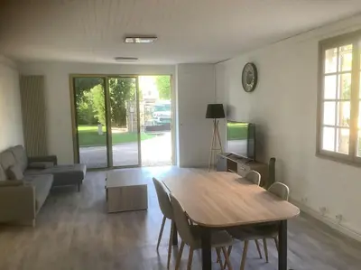 a living room with a wooden table and a couch at Le chant de la sorgue in LʼIsle-sur-la-Sorgue