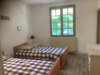 two beds in a room with a window at Le chant de la sorgue in LʼIsle-sur-la-Sorgue