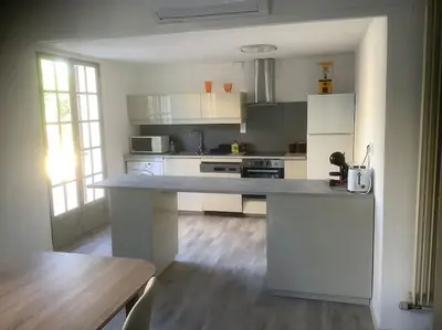 a kitchen with white cabinets and a counter top at Le chant de la sorgue in LʼIsle-sur-la-Sorgue
