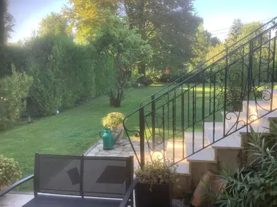 a balcony with a staircase and some plants and a yard at Le chant de la sorgue in LʼIsle-sur-la-Sorgue