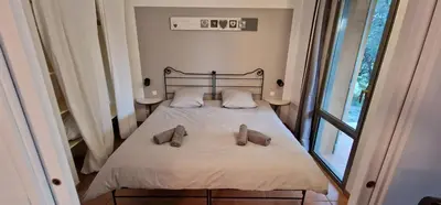 a bedroom with a bed with two shoes on it at Appartement climatisé sur golf de L'Isle-Sur-La-Sorgue in Saumane-de-Vaucluse