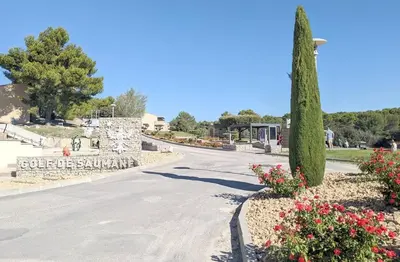 a street in a park with a tree and flowers at Appartement climatisé sur golf de L'Isle-Sur-La-Sorgue in Saumane-de-Vaucluse
