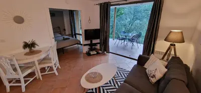 a living room with a couch and a table at Appartement climatisé sur golf de L'Isle-Sur-La-Sorgue in Saumane-de-Vaucluse