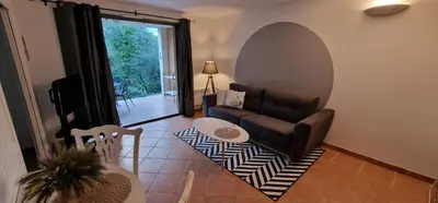 a living room with a couch and a table at Appartement climatisé sur golf de L'Isle-Sur-La-Sorgue in Saumane-de-Vaucluse