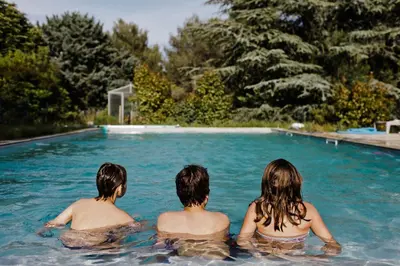 three people sitting in a swimming pool at Le domaine de Gaïa in Aix-en-Provence