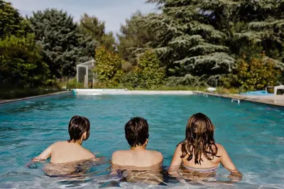 a group of three people sitting in a swimming pool at Le domaine de Gaïa in Aix-en-Provence