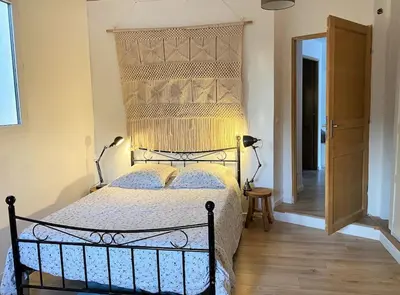 a bedroom with a large bed with a wooden floor at Le domaine de Gaïa in Aix-en-Provence