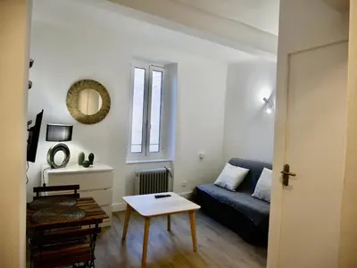 a living room with a blue couch and a table at Studio Garrigue in La Fare-les-Oliviers