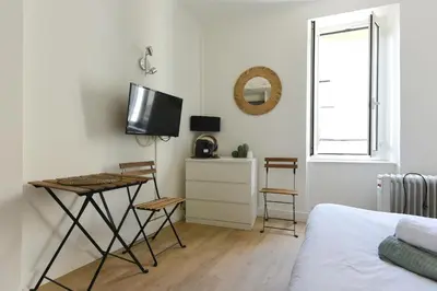 a bedroom with a table and a tv on a wall at Studio Garrigue in La Fare-les-Oliviers