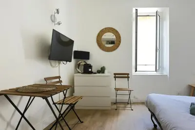 a bedroom with a table and a bed and a television at Studio Garrigue in La Fare-les-Oliviers