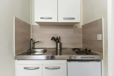 a small kitchen with a sink and a stove at Studio Garrigue in La Fare-les-Oliviers
