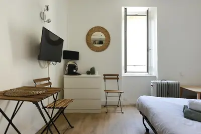 a bedroom with a desk and a table and a bed at Studio Garrigue in La Fare-les-Oliviers