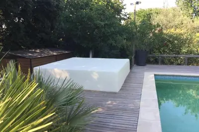 a bath tub sitting next to a swimming pool at House quiet and wooded in Aix-en-Provence
