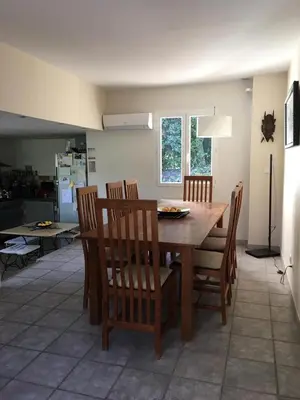 a dining room with a wooden table and chairs at House quiet and wooded in Aix-en-Provence