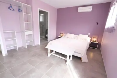 a bedroom with a white bed and purple walls at very pleasant villa with private swimming pool, in a residential area near the center of saint-rémy-de-provence - 8 people in Saint-Rémy-de-Provence