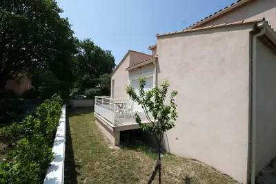 a house with a porch next to a building at very pleasant villa with private swimming pool, in a residential area near the center of saint-rémy-de-provence - 8 people in Saint-Rémy-de-Provence