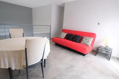 a living room with a red couch and a table at very pleasant villa with private swimming pool, in a residential area near the center of saint-rémy-de-provence - 8 people in Saint-Rémy-de-Provence