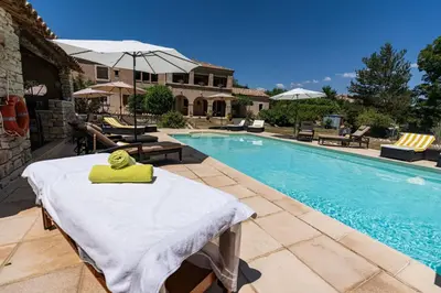 a pool with a table with a yellow towel on it at Mon Ventoux - Cozyhotes in Sault-de-Vaucluse