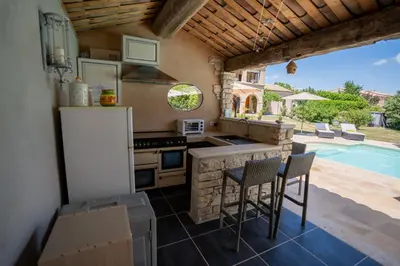 a kitchen with a refrigerator and a table and chairs at Mon Ventoux - Cozyhotes in Sault-de-Vaucluse