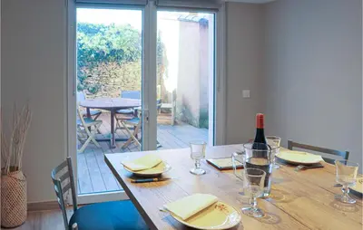 a dining room table with a bottle of wine and a glass at Stunning Apartment In Villes Sur Auzon in Villes-sur-Auzon