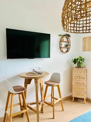 a table with two chairs and a tv on a wall at Studio Nuitée en Provence 2 in Aix-en-Provence
