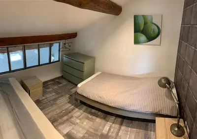 a small bedroom with a bed and a lamp at Clos du Cardinal avec piscine in LʼIsle-sur-la-Sorgue